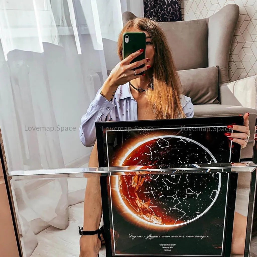 Девушка фотографирует себя в зеркале со звёздной картой в оранжевых тонах